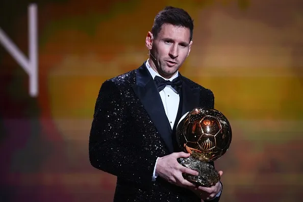 Messi segurando uma bola de ouro